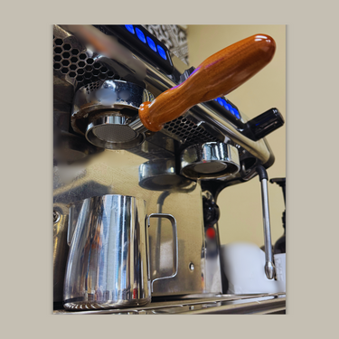 Close-up of an espresso machine with a wooden handle on a beige background